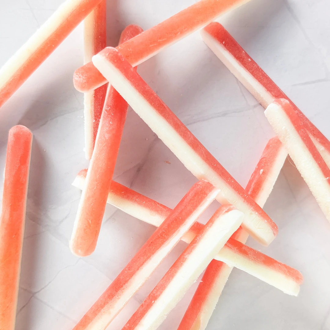 Bâtonnets glacés pastèque et fromage blanc pour chien, démoulés sur une assiette