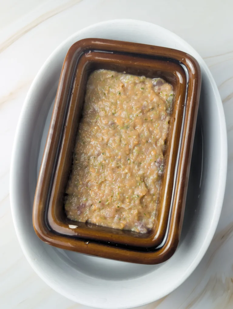 Moulage de la farce dans une terrine avant cuisson au bain-marie