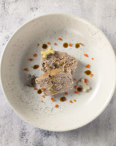 Dressage de la pâtée pour chat dans une assiette beige