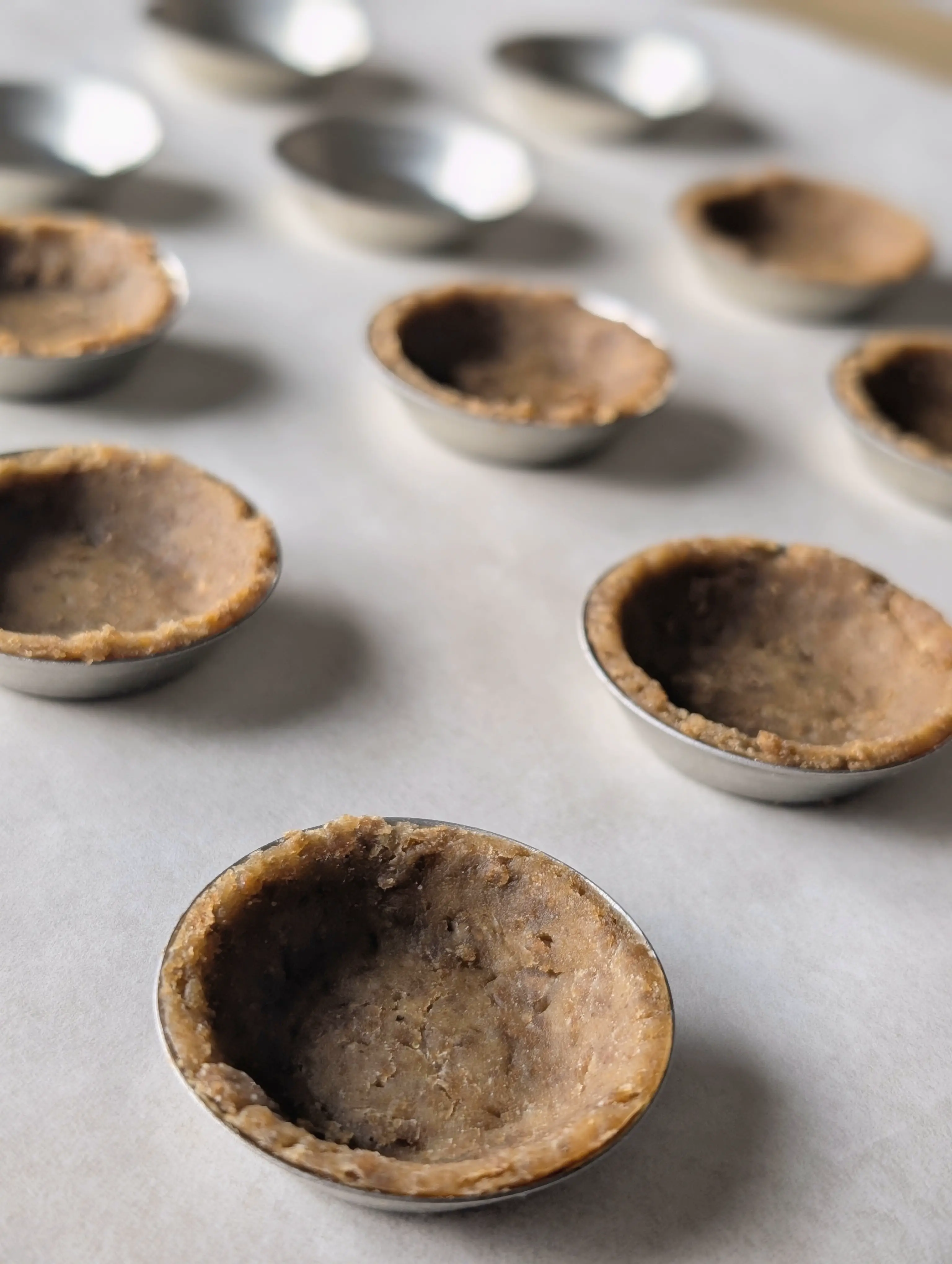 Vue de la pâte brisée aux croquettes dans des mini moules à tartelette